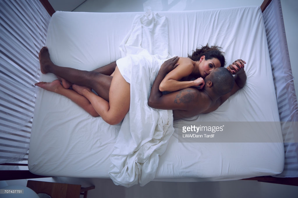 Woman and man cuddling in bed